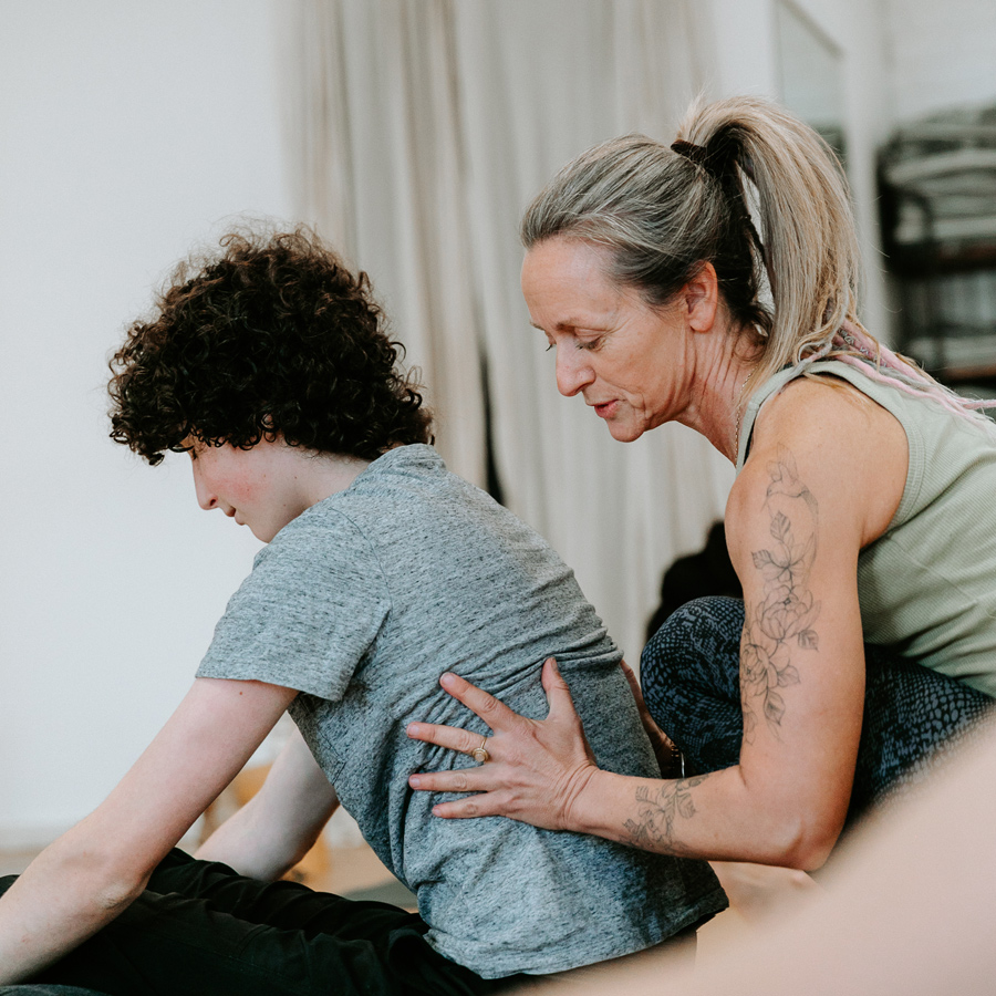 yoga teacher helping student